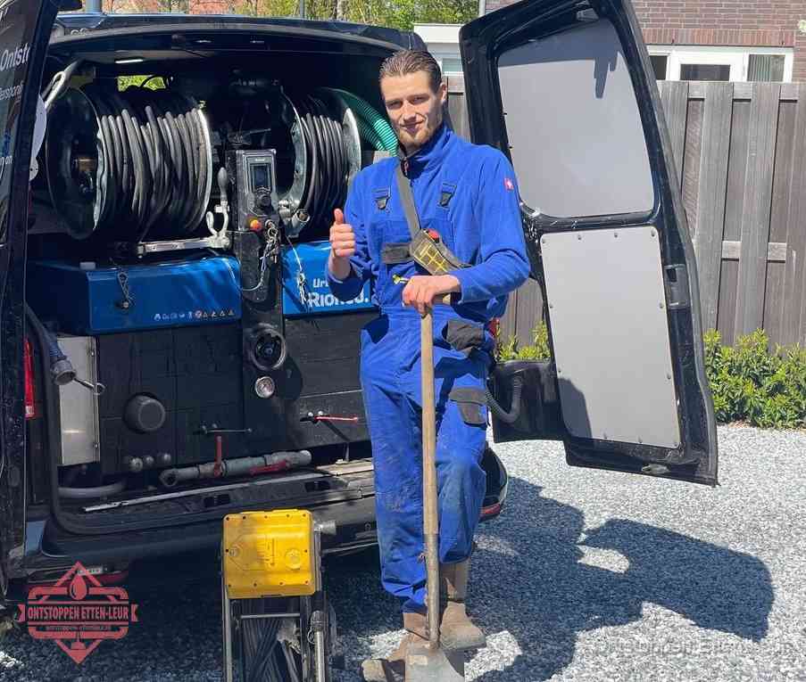 Een monteur bij de werkbus met grote hogedruk-slanghaspels, apparatuur voor hardnekkige afvoerverstoppingen in Etten-Leur