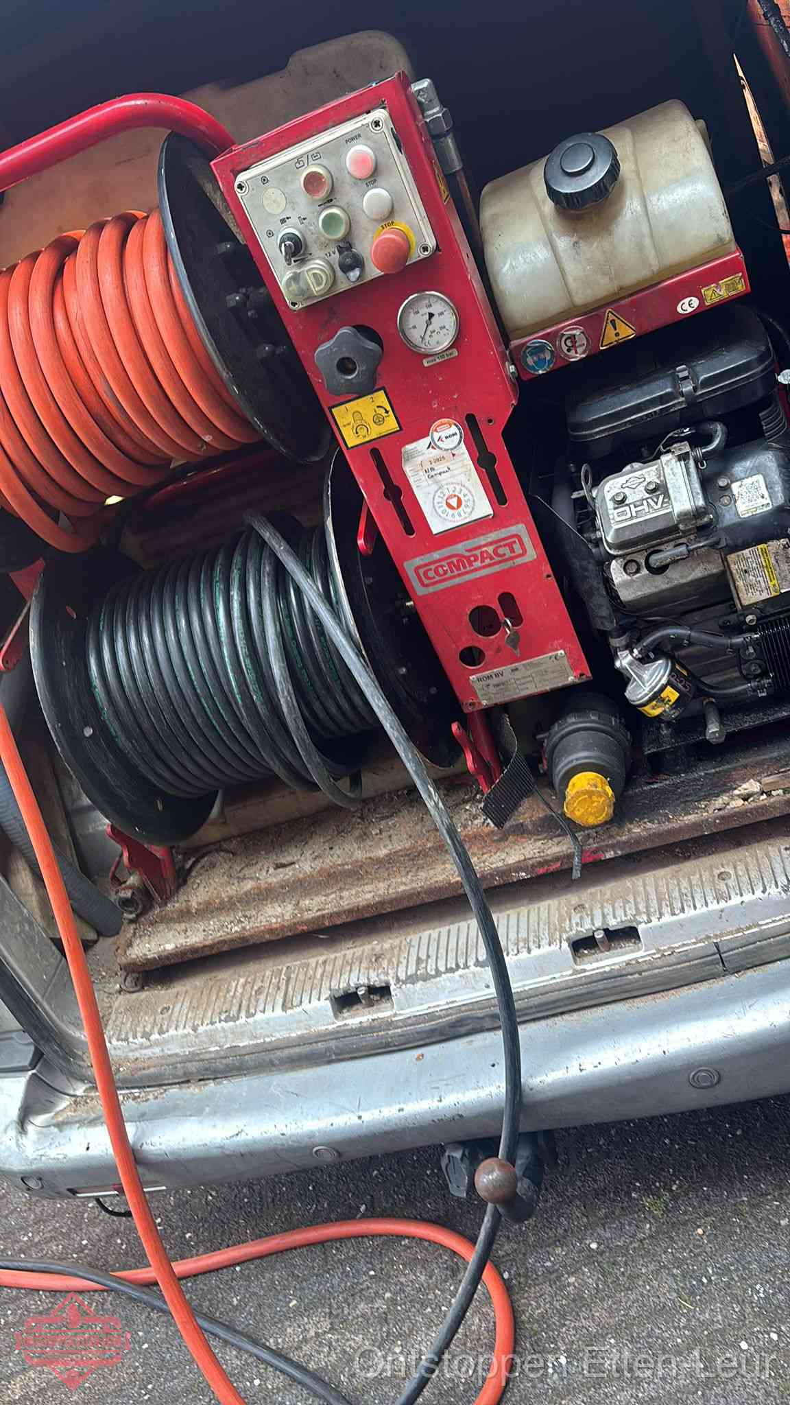 Een rood hogedruk-rioolreinigingstoestel met slangen in de laadbak van de bedrijfsbus, apparatuur voor een hardnekkige wc-verstopping in Etten-Leur