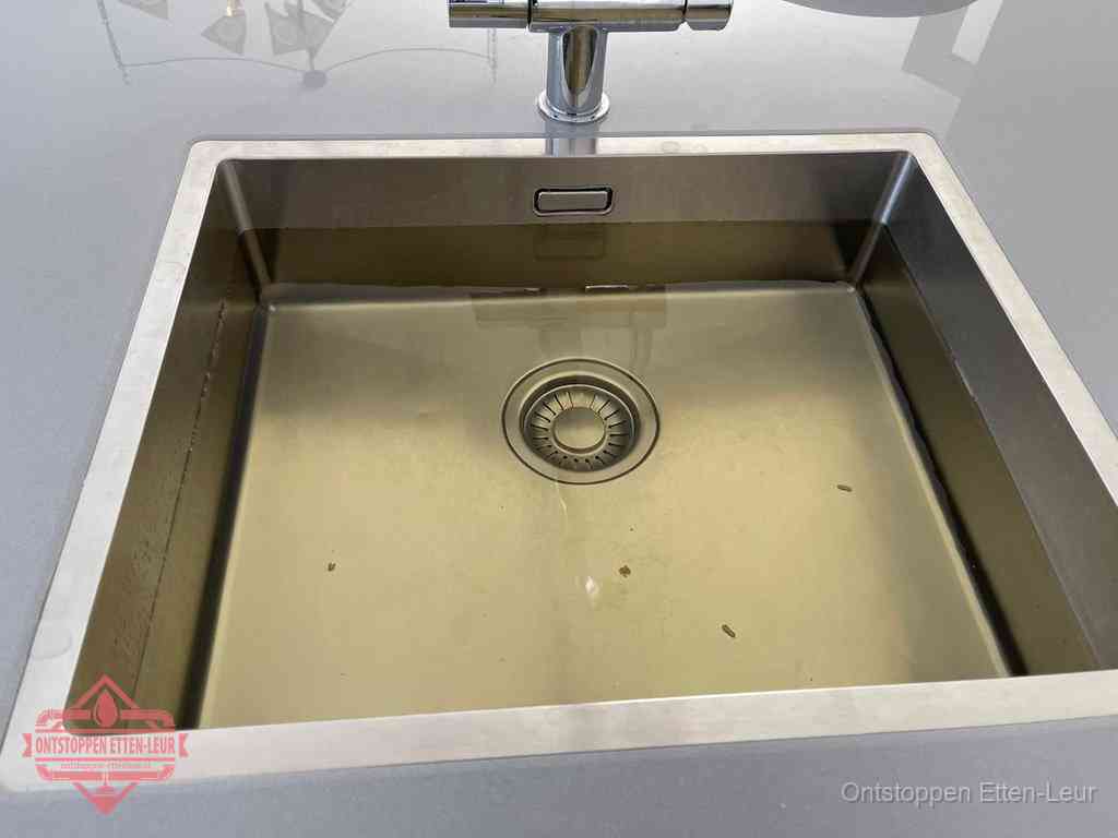 Stilstaand water in een rvs spoelbak dat niet wegloopt, een duidelijk signaal van een gootsteenverstopping in Etten-Leur