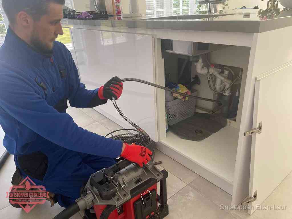 Een monteur reinigt de keukenafvoer grondig met een veermachine om terugkerende gootsteenverstoppingen te voorkomen in Etten-Leur