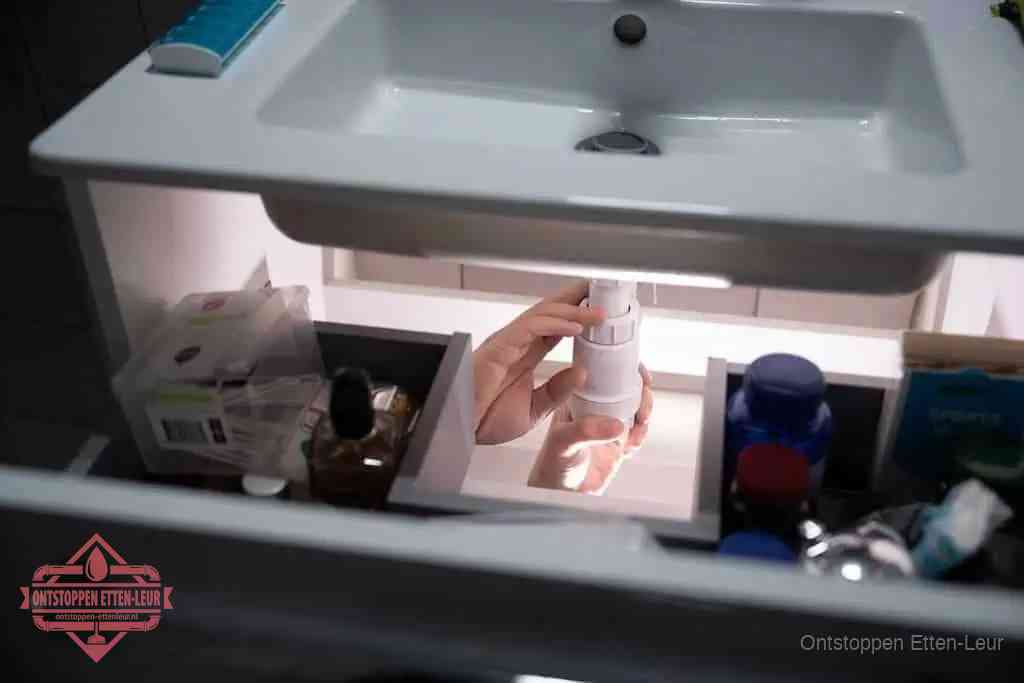 Een pompfles met zeep boven een wastafel in de toiletruimte, de warm water en afwasmiddel-methode om de wc te ontstoppen in Etten-Leur