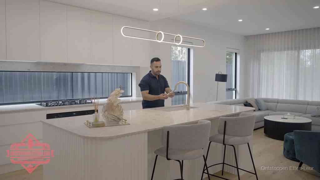 Een bewoner bij de keukenspoelbak die zelf aan de slag gaat met een verstopte gootsteen in Etten-Leur